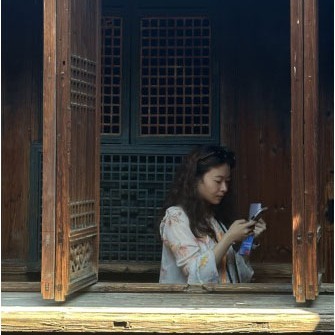 Chuyu Xiong reading in a window.