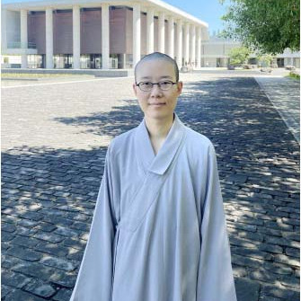 Changzhong standing in front of a columned building.